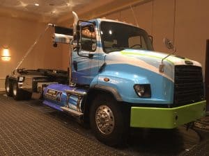 heavy-duty Freightliner CNG trash roll-off hoist truck on display