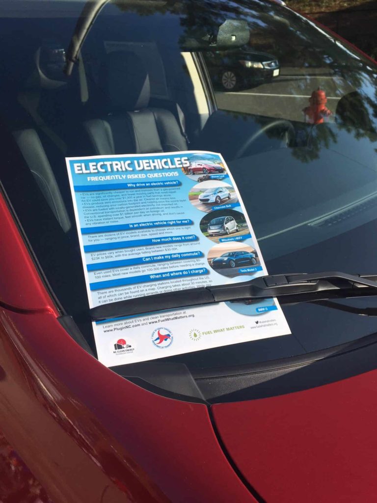 Electric Vehicle frequently asked question pamphlet on a red car