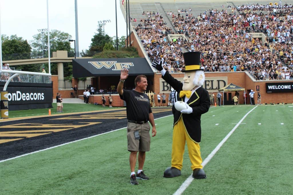Clean Transportation Director Rick Sapienza accepting game ball from Wake Forest’s mascot